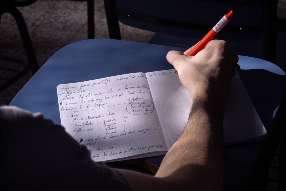 Student writing notes in a notebook